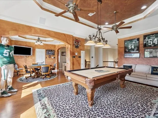 a living room with furniture a chandelier and a flat screen tv