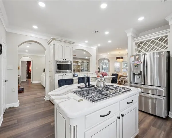 a kitchen with stainless steel appliances kitchen island granite countertop a refrigerator and a stove top oven