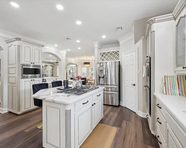 a kitchen with white cabinets and stainless steel appliances