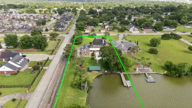an aerial view of residential houses with outdoor space and lake view