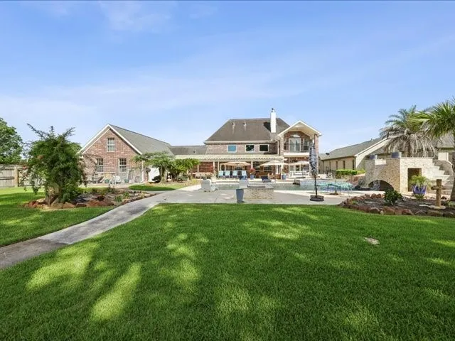 a view of a big house with a big yard and large trees