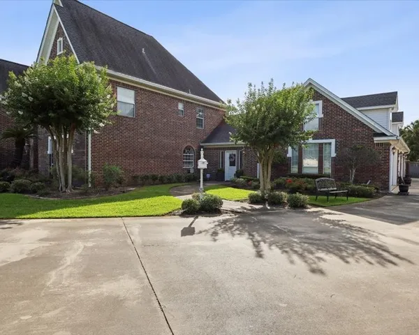 a view of a house with backyard and a tree