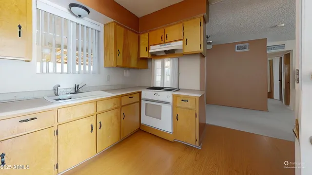 a kitchen with stainless steel appliances granite countertop a sink a stove and a refrigerator