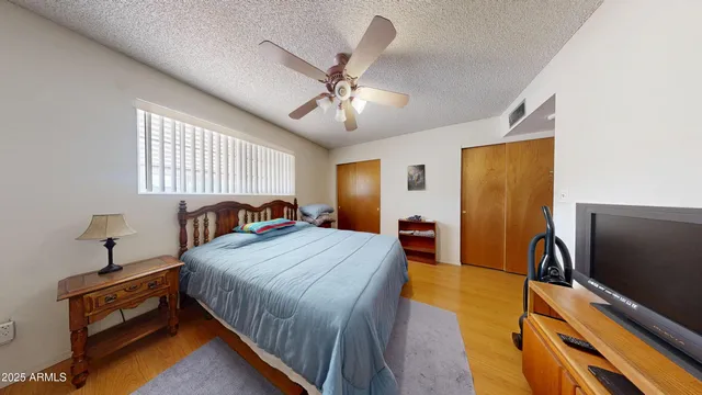 a bedroom with a bed and a flat tv screen on dresser