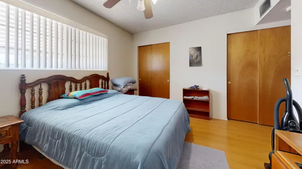 a bedroom with a bed and a flat tv screen on dresser