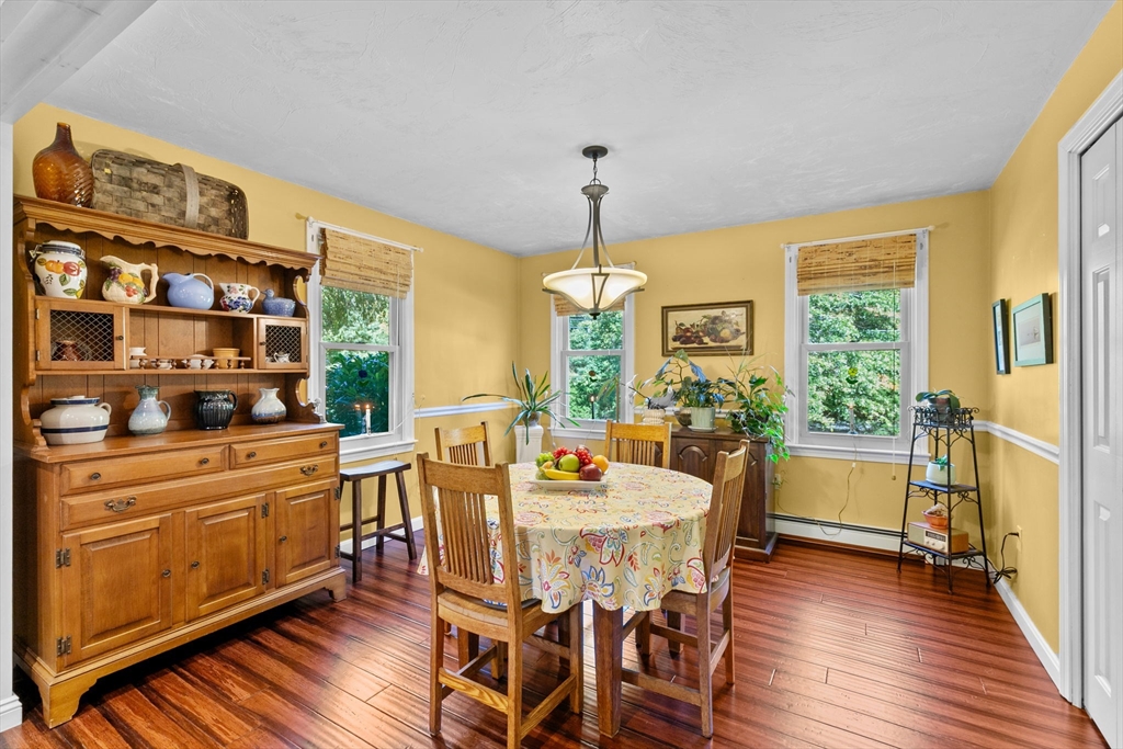 150 Ryder Road Rochester, MA 02770 - Photo 12 of 42 a dining room with wooden floor a chandelier a wooden table and chairs