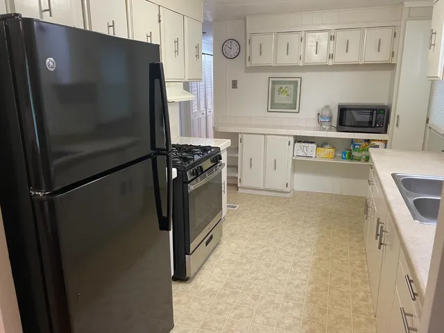a kitchen with stainless steel appliances a refrigerator and a stove top oven