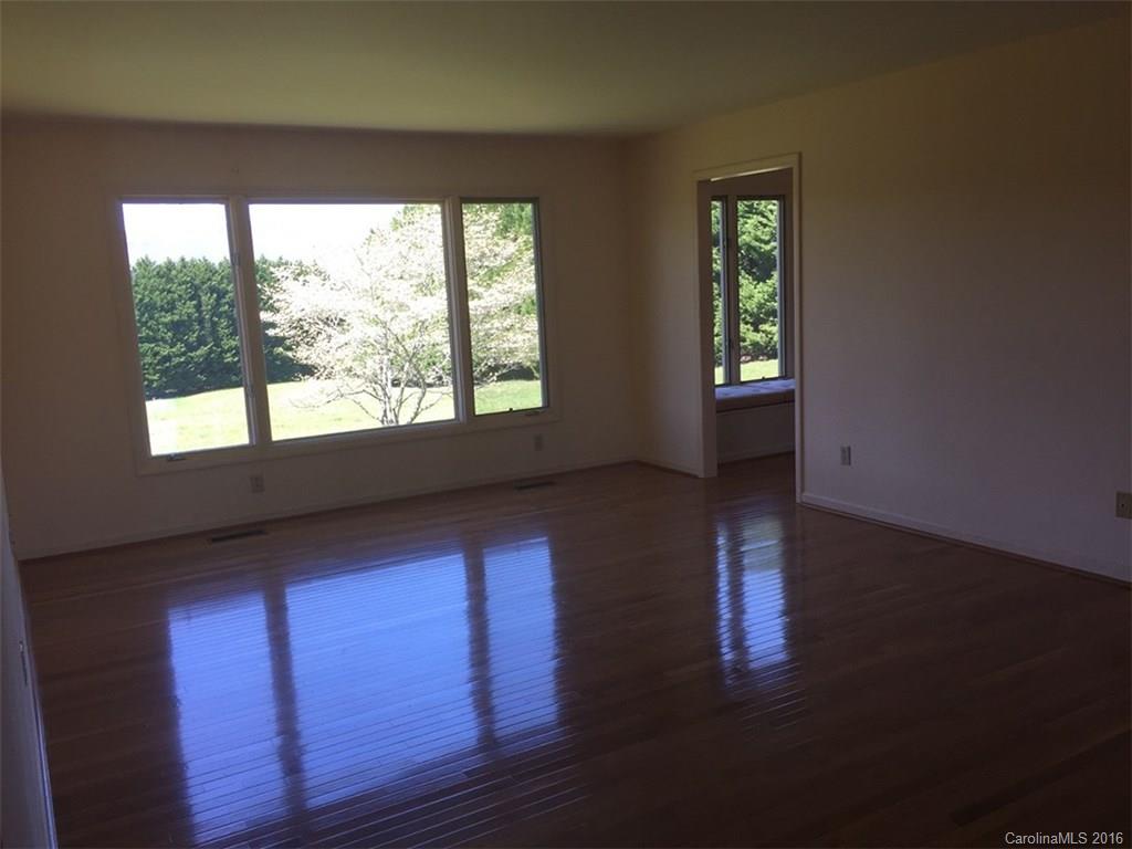 156 Luther Durham Road Tryon, NC 28782 - Photo 16 of 23 a view of an empty room with wooden floor and a window