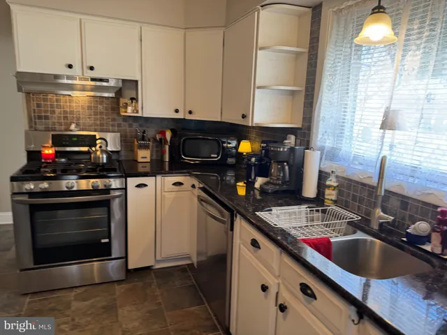 a kitchen with stainless steel appliances a stove a sink and a microwave