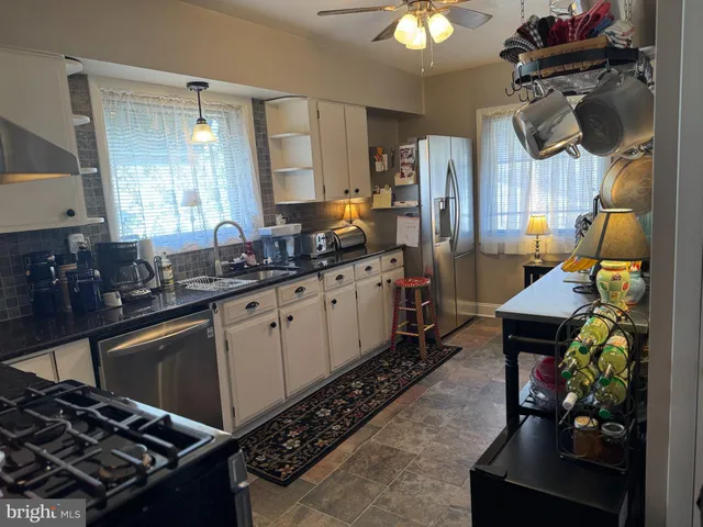 a kitchen with stainless steel appliances a sink stove and cabinets