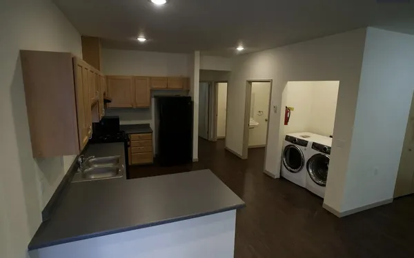 a view of a kitchen with a refrigerator a stove top oven and cabinets