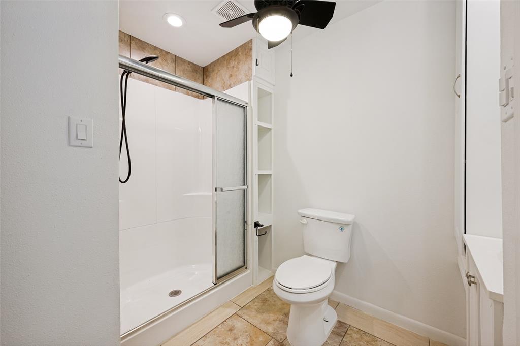 2316 Cunningham Street Irving, TX 75062 - Photo 19 of 22 Shower with sliding glass doors, white subway tile surround, and an overhead rain shower head
