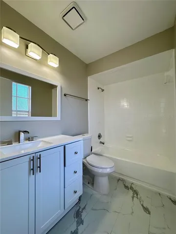 a bathroom with a double vanity sink toilet mirror and bathtub