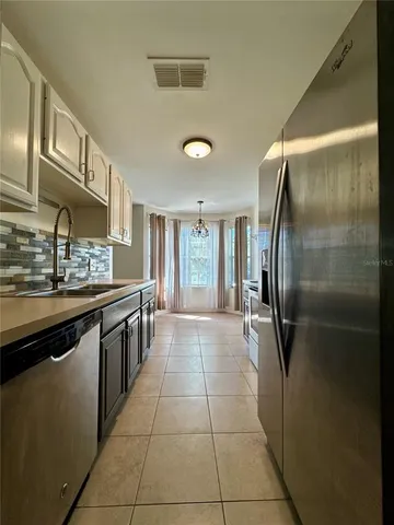 a kitchen with stainless steel appliances granite countertop a refrigerator and a sink
