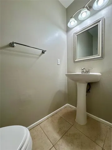 a bathroom with a sink a toilet and mirror