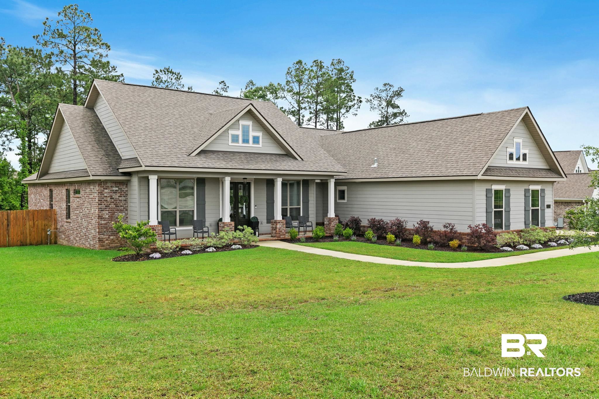 13233 Ibis Boulevard Daphne, AL 36527 - Photo 69 of 100 Contemporary ranch-style residence featuring a combination of brick and horizontal siding, a covered front porch, a multi-gabled roof, decorative window shutters, and a manicured lawn with established landscaping