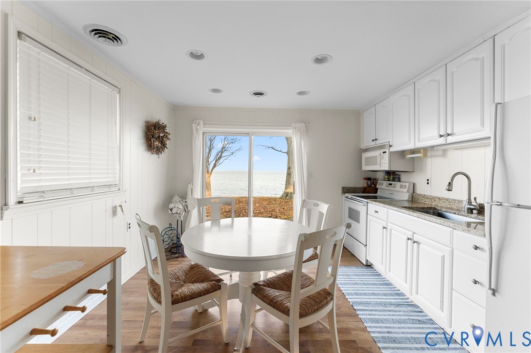 63 Bayview Lane Hague, VA 22469 - Photo 13 of 23 a kitchen with stainless steel appliances granite countertop a white cabinets and wooden floor