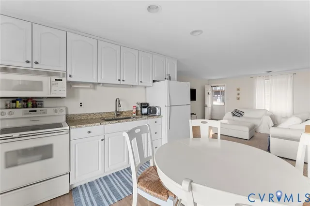 a living room with white cabinets and white appliances