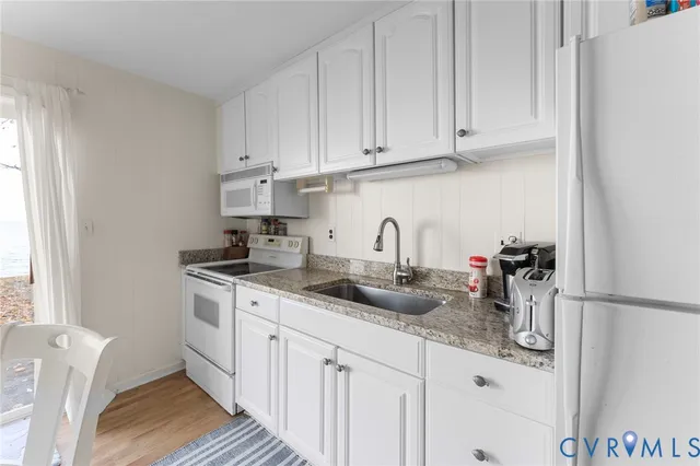 a kitchen with stainless steel appliances granite countertop a sink and a white cabinets