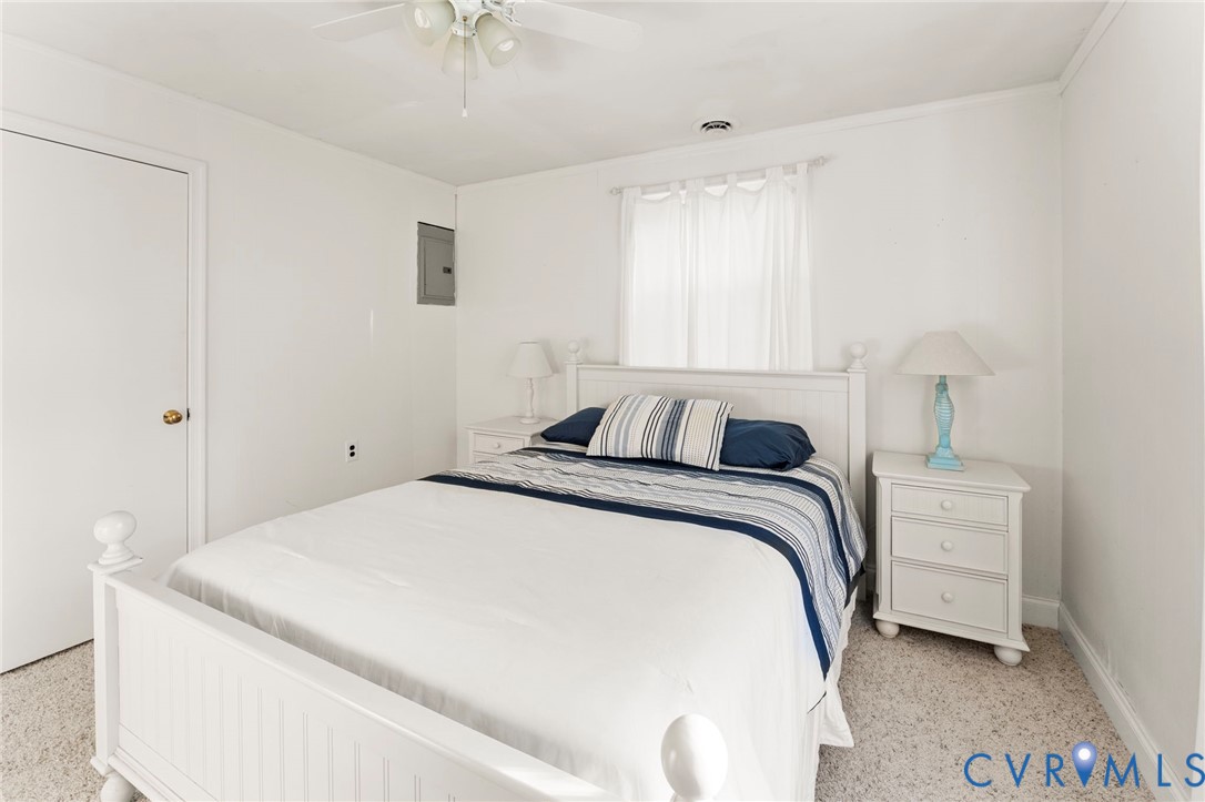 63 Bayview Lane Hague, VA 22469 - Photo 17 of 23 a bed room with a bed and a chandelier