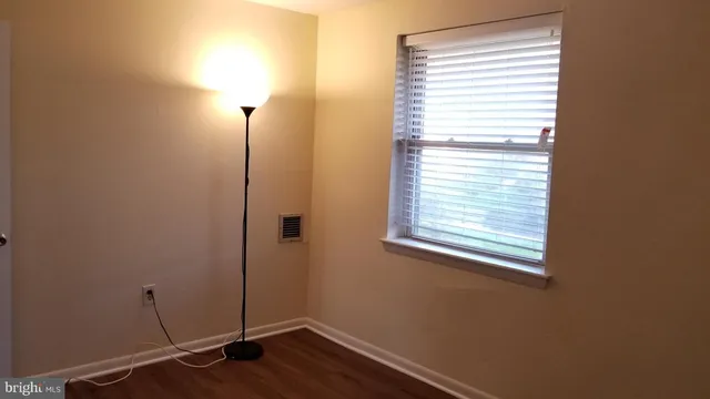 a view of a room with wooden floor and a window