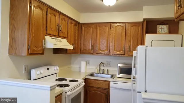 a kitchen with a cabinets and white appliances
