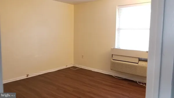 a view of a room with wooden floor and a window
