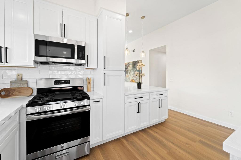 5055 Andrew Jackson Street Oceanside, CA 92057 - Photo 11 of 43 a kitchen with stainless steel appliances a stove a microwave and cabinets