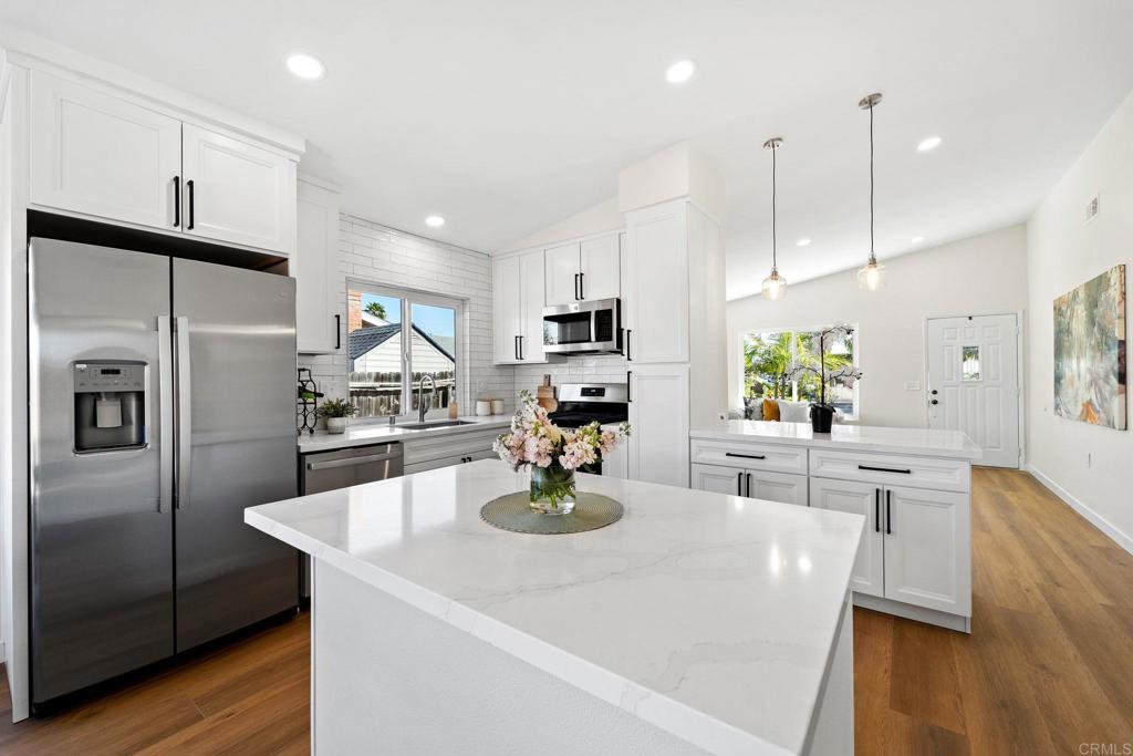 5055 Andrew Jackson Street Oceanside, CA 92057 - Photo 12 of 43 a kitchen with stainless steel appliances a dining table chairs stove and refrigerator