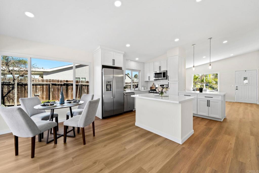 5055 Andrew Jackson Street Oceanside, CA 92057 - Photo 16 of 43 a kitchen with stainless steel appliances kitchen island granite countertop a table chairs and a refrigerator