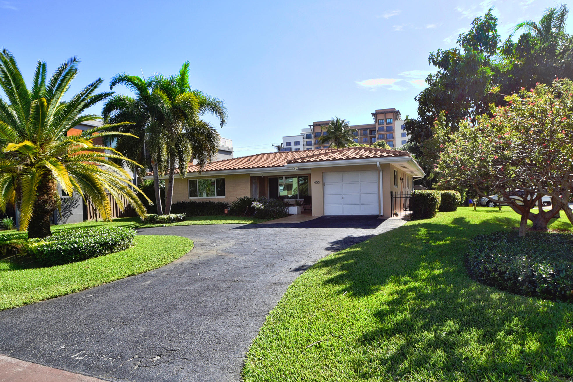 400 Northeast 2nd Street Boca Raton, FL 33432 - Photo 4 of 40 a front view of a house with a garden and trees
