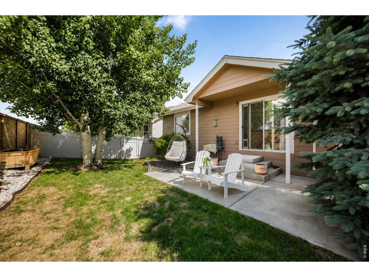 148 Beacon Way Windsor, CO 80550 - Photo 32 of 36 Covered concrete patio overlooking the backyard with mature landscaping and shade trees.