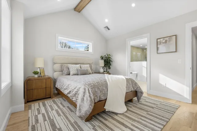 a spacious bedroom with a large bed and a wooden floor