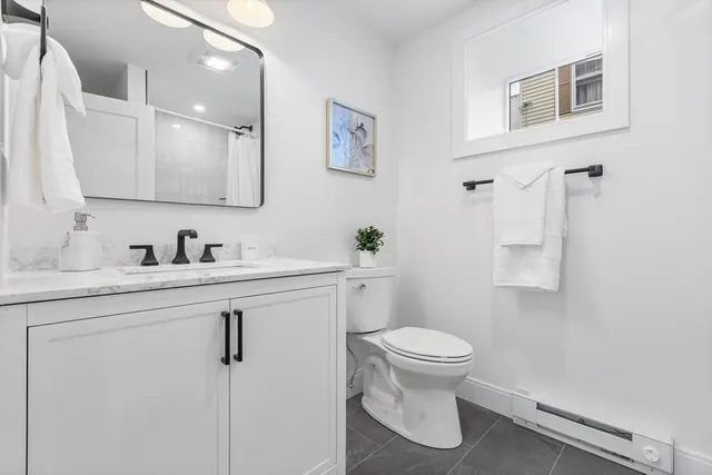 a bathroom with a sink toilet and mirror