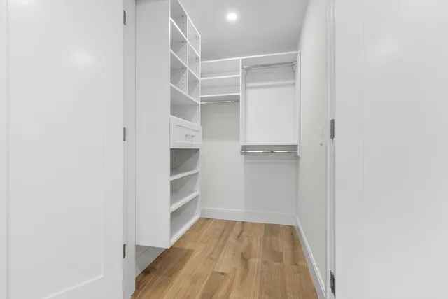a view of walk in closet with empty racks