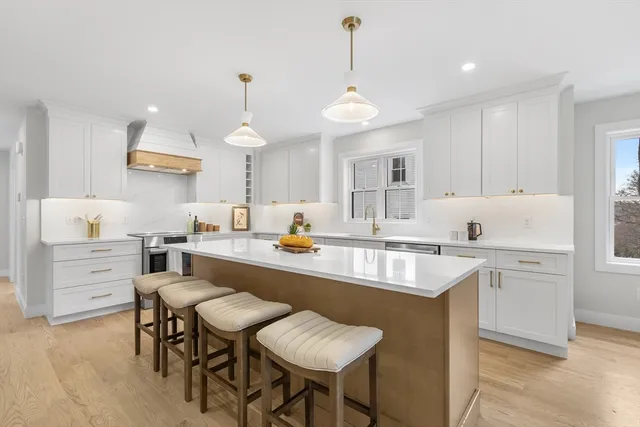a large kitchen with kitchen island a sink table and chairs
