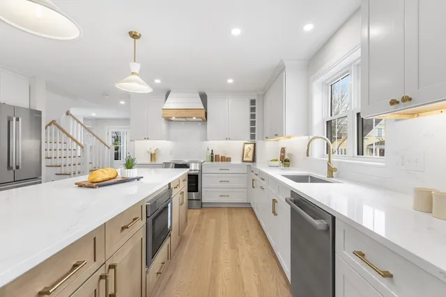 a large kitchen with stainless steel appliances lots of counter space and wooden floor