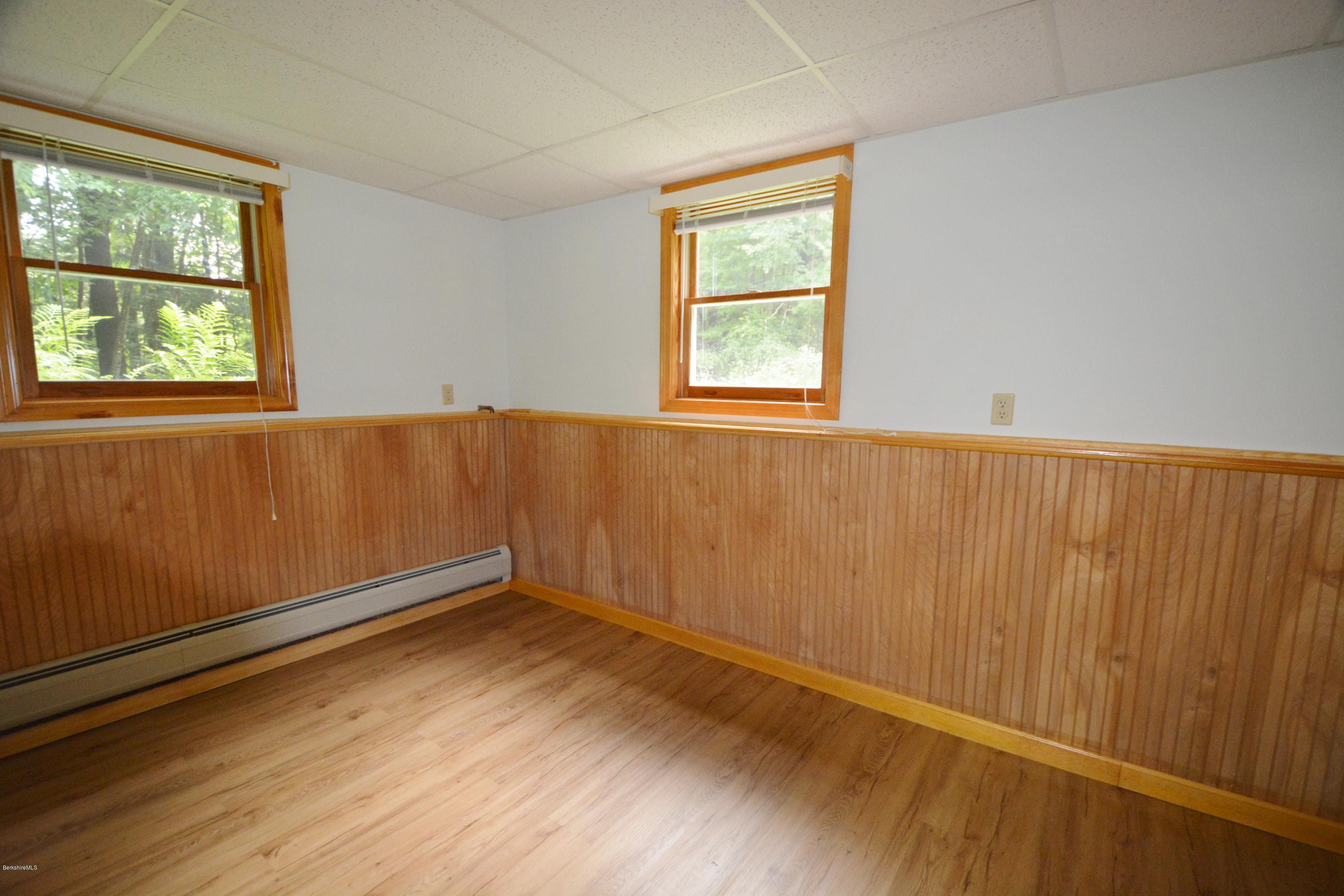 189 Tolland Road Otis, MA 01029 - Photo 12 of 16 an empty room with wooden floor and windows