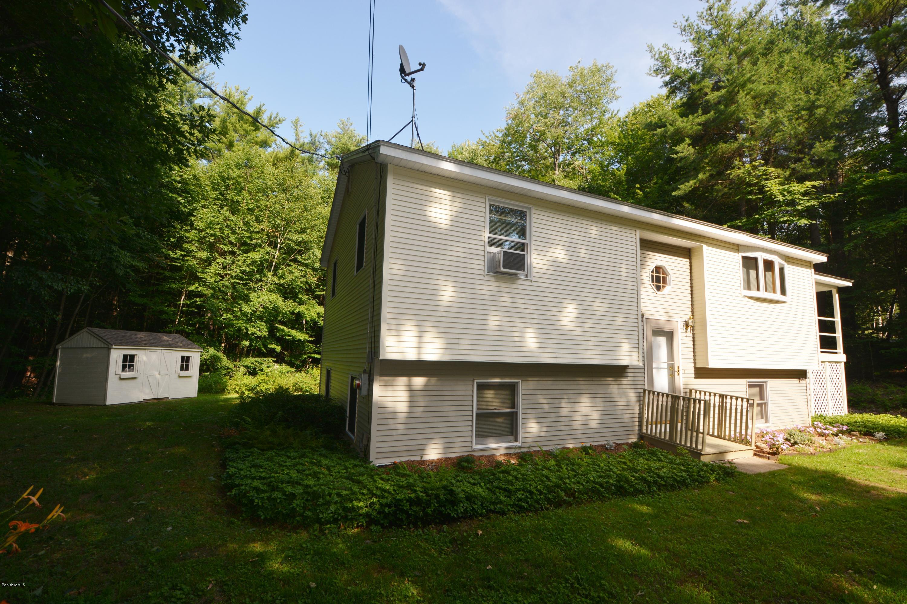 189 Tolland Road Otis, MA 01029 - Photo 14 of 16 a front view of a house with a yard and garage