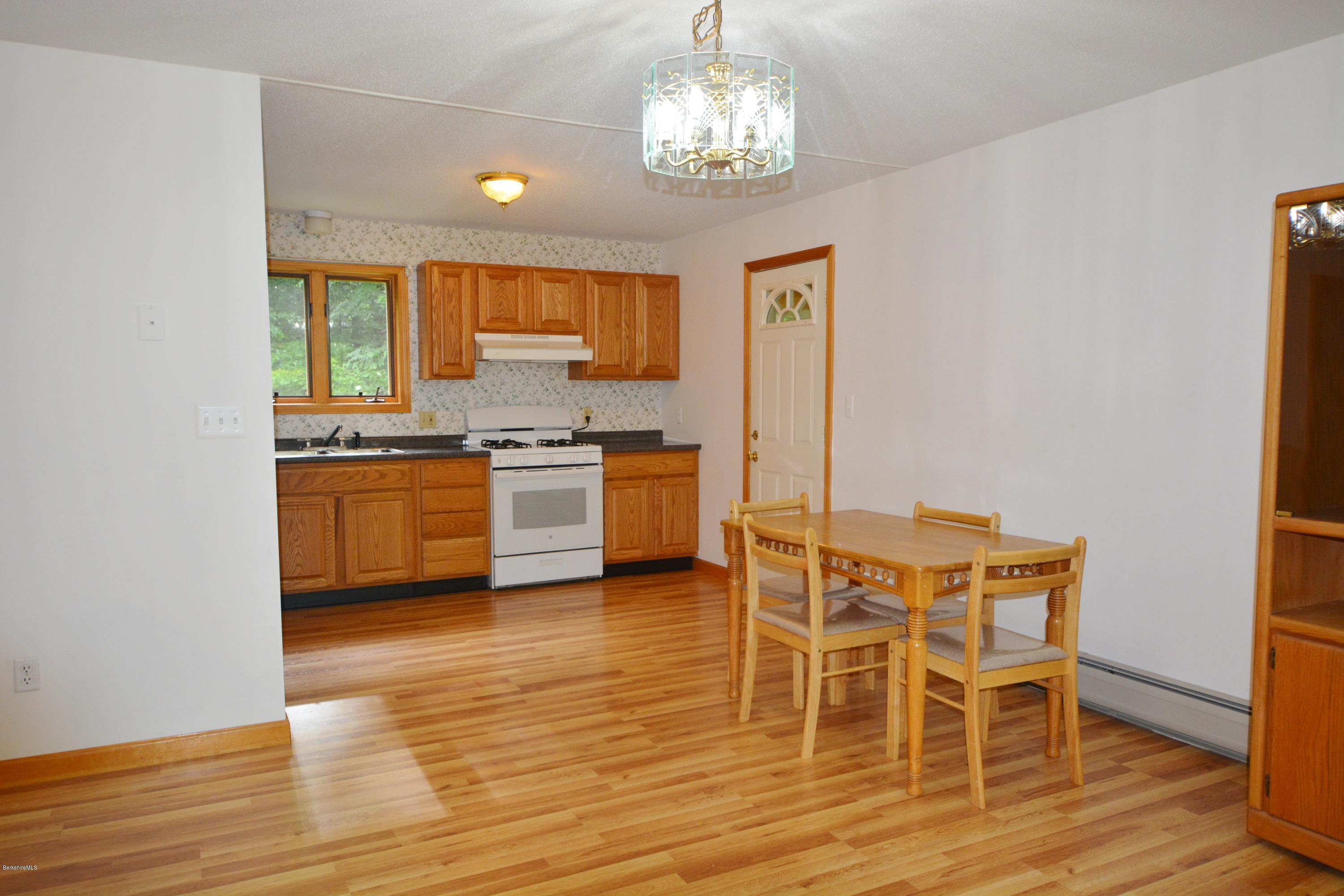 189 Tolland Road Otis, MA 01029 - Photo 3 of 16 a view of a dining room with furniture a chandelier and wooden floor