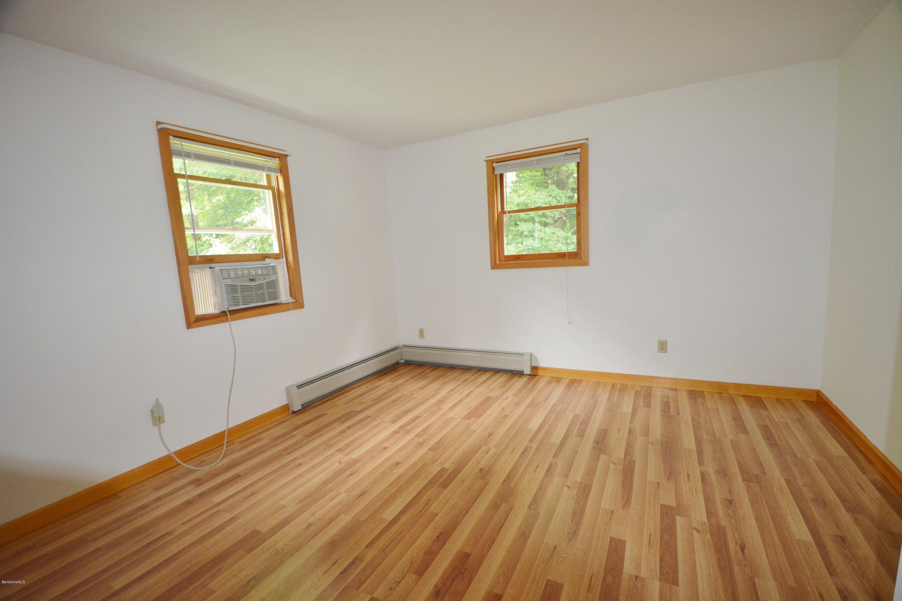 189 Tolland Road Otis, MA 01029 - Photo 6 of 16 a view of an empty room with wooden floor and a window