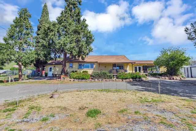 a front view of house with yard and trees around