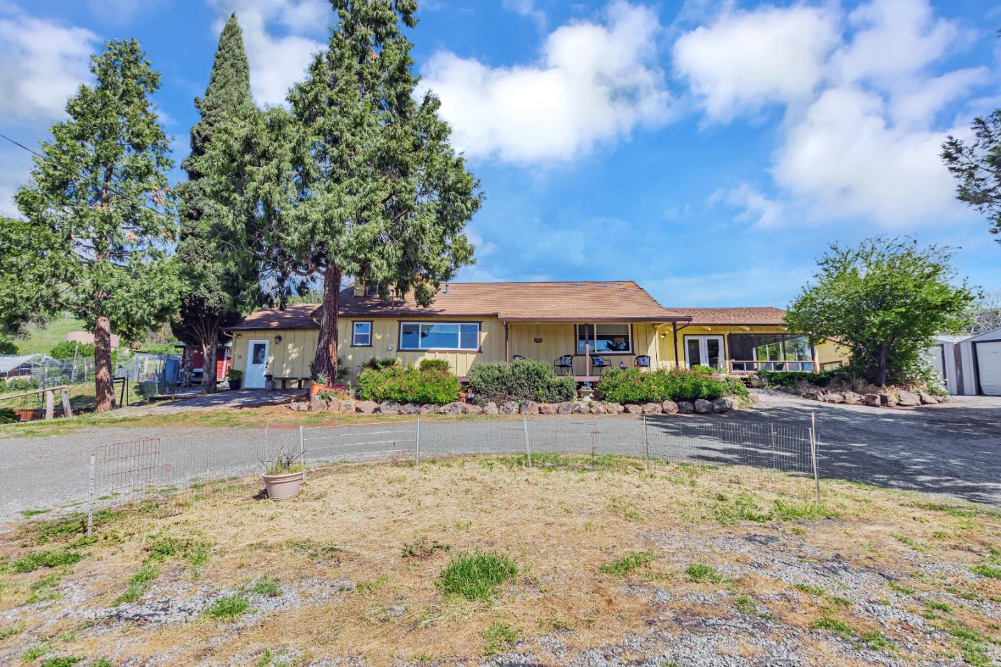 a front view of house with yard and trees around