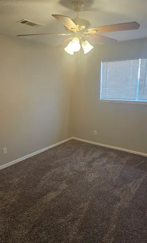 a view of a small space with wooden floor and fan