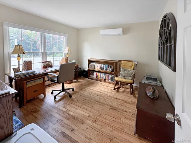 a view of a workspace with furniture and a window