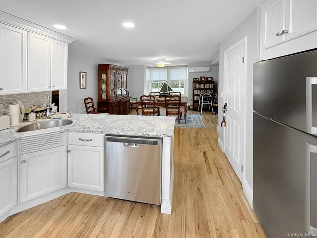 a kitchen with a sink a stove cabinets and wooden floor