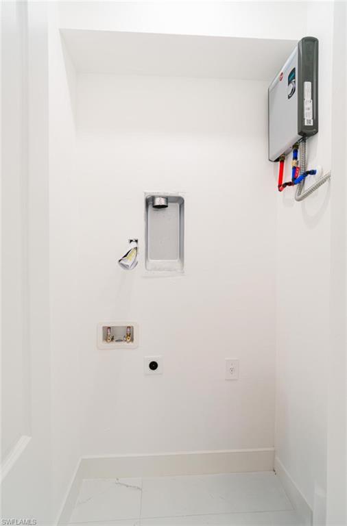 907 Homestead Road South Lehigh Acres, FL 33974 - Photo 25 of 43 Dedicated utility space featuring a tankless water heater, white tile flooring, and clean white walls