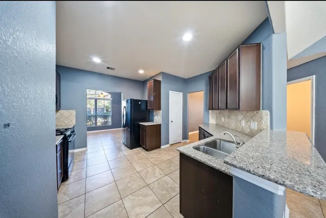 a kitchen with stainless steel appliances granite countertop a sink stove and cabinets
