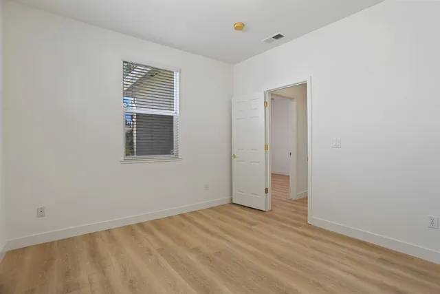 a view of empty room with window and ceiling fan