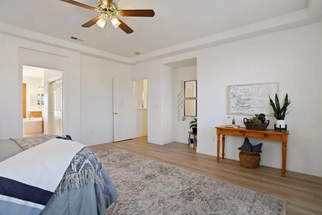 a view of a white house with a yard and potted plants